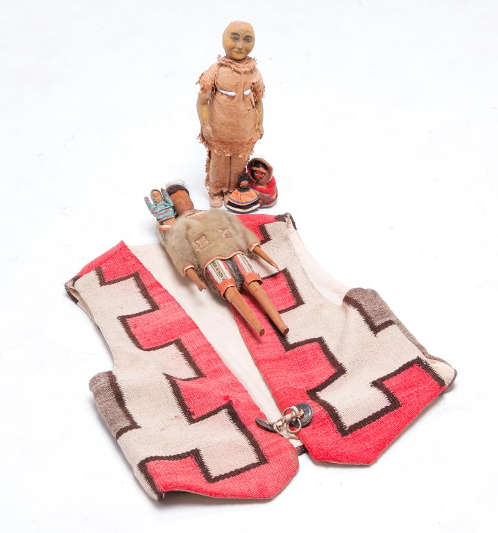 FOUR DOLLS AND A NAVAJO BLANKET VEST.: Twentieth century. Man's vest made from a blanket with cloth interior and silver conchos. Label "A Design by Hester, Santa Fe, NM". 23"l. And four dolls. Wood carved Inuit with partial seal skin cloth