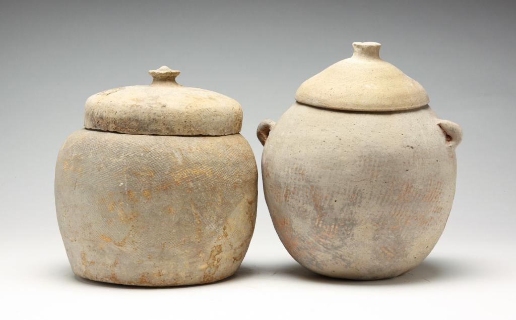 TWO KOREAN COVERED POTTERY JARS. (1 of 5)