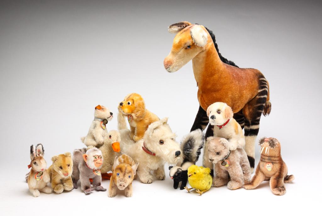TEN STEIFF ANIMALS AND FOUR OTHER TOY ANIMALS.: Late 20th century. Steiff including Okapi, 14.5"h. Paddy, Foxy, Bear, Coco, piggy, skunk, Revve Susi, Manni and a puppy. And German duck, chicken, Scotty dog and lionness.
