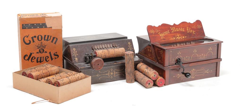 TWO AMERICAN COB ROLLER ORGANS.: Ca. 1900. "The Gem Roller Organ" in original paint and stenciling. Make-do crank. 7.5"h. 14.5"w. 14.25"d. And a "Home Music Box" refinished and restenciled. 11.25"h. 14.25"w. 15"d. Includes cobs.