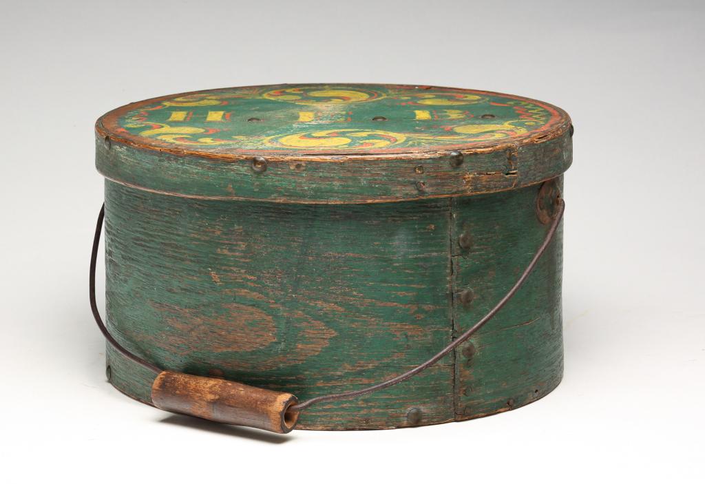 AMERICAN DECORATED BENTWOOD CARRIER.: Second half 19th century. Lapped seams with copper tacks and brass tacks, bail handle. Green paint on base is original, lid has enhanced paint with flourishes and "HEB". Age splits and wear. 6.5"h. 11