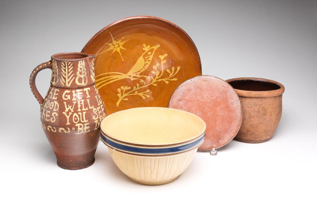 FIVE PIECES OF STONEWARE INCLUDING REDWARE.: American, 19th and 20th century. Including an early redware crock, 6.25"h., early redware trivet, 8"w., a stoneware mixing bowl, 9.5"d., a redware silp decorated charger, 13.5"w., and a decorated redw