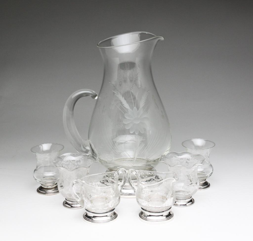 SEVEN STERLING SILVER FOOTED GLASS PIECES.: American, 20th century. Including a pitcher, 11"h., cream and sugar, 3"h., and bud vases, 3.25"h. Mostly Cambridge "Rose Point". Creamer has repaired handle.