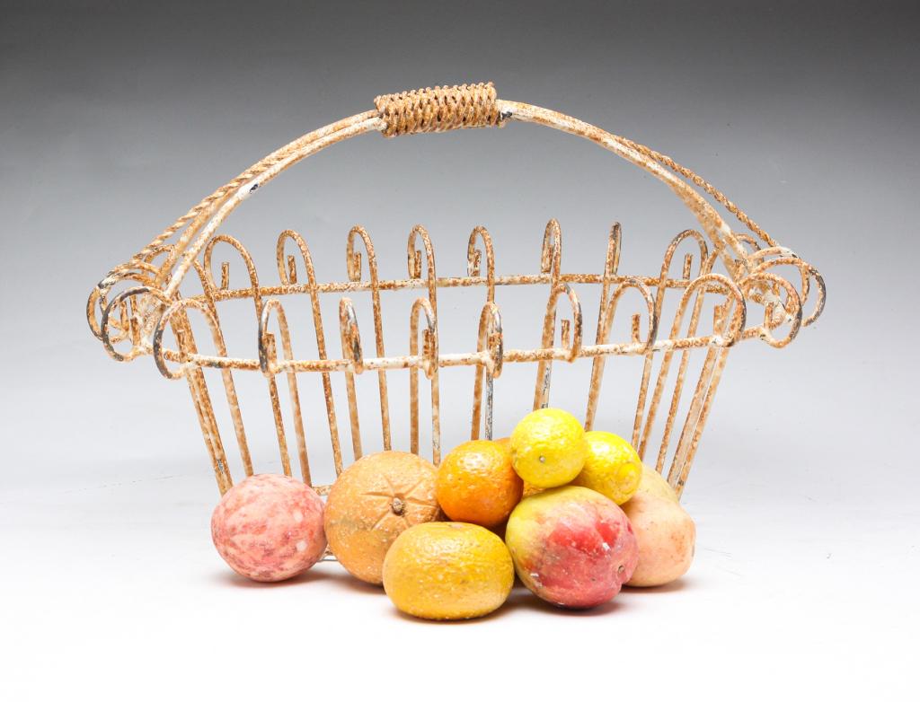 TEN PIECES OF STONE FRUIT IN WIRE BASKET.: American and European, 20th century. Life-size and miniature lemons, peaches and oranges. In a late wire basket, 9.75"h. 16.5"l.