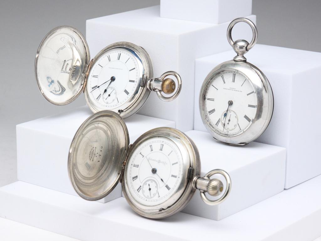 THREE COIN SILVER COLUMBUS POCKET WATCHES.: Fourth Qtr - 19th century. Three Columbus Watch Co. 18S pocket watches including: OF, 11J, oversize case, KW & S (no key), Dueber Newport coin case, serial #20139 (1882), dial with hairlines; HC, 15J,