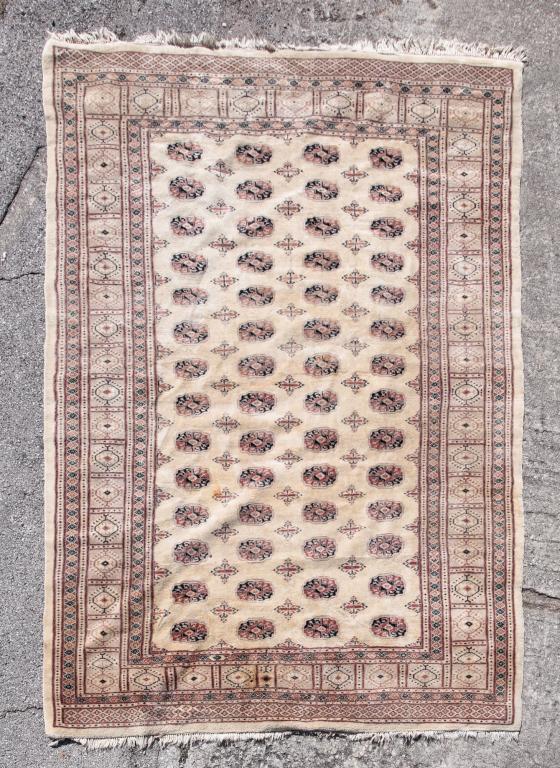 BOKHARA RUG.: Last quarter 20th century. Ivory ground and thick pile. Stains. 7'2" x 9'9".