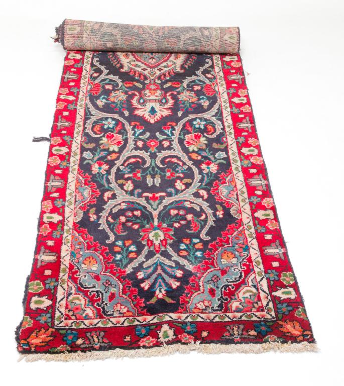 ORIENTAL RUNNER.: Late 20th century, wool. Blue field, red and cream border and floral pattern. Wear particularly to edge binding. 3'w. 11'3"l.