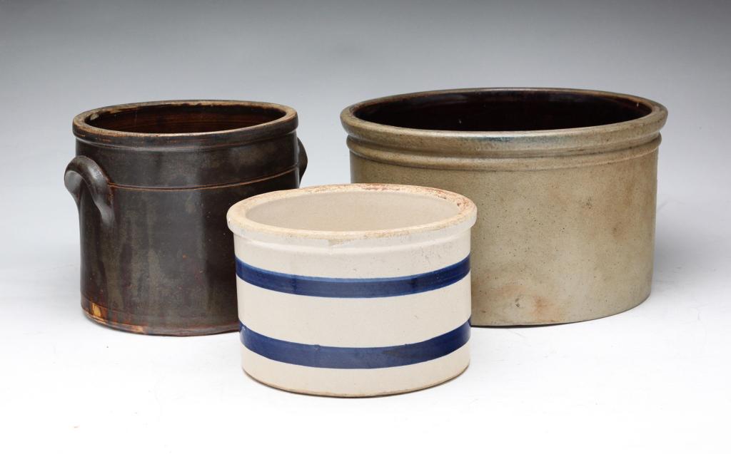 THREE STONEWARE CROCKS.: Nineteenth-20th century. One crock has Albany slip, one has white glaze with blue stripes. Flakes and hairline. 5.5"h. 9.5"d., 5.75"h., 4.5"h.