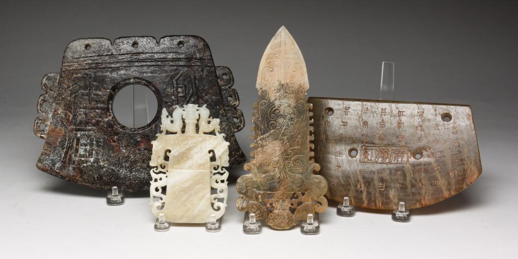 FOUR CHINESE ARCHAIC STYLE STONE BLADES.: Twentieth century or earlier. Various stones. Dagger with applied mud wash, 8"l. and three axes. Carved crest, 4.75"l., incised text, 8"w. and shallow relief carving. 9"w.