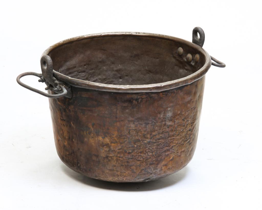 COPPER CANDY KETTLE.: American or European, 2nd half 19th century. Large kettle with dovetailed construction and iron handles with hanger attachments. Multiple dents, handles have repair. 17.5"h. 22.5"d. overall.