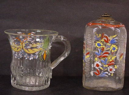 TWO ENAMELED PIECES OF BLOWN GLASS. Mug: TWO ENAMELED PIECES OF BLOWN GLASS. Mug with applied handle. Delicate pastel floral swags in good condition. 3 3/4"h. And a half post case bottle with flowers in red, blue, yellow and white. The neck