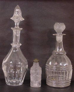 THREE PIECES OF CLEAR GLASS. Two decante: THREE PIECES OF CLEAR GLASS. Two decanters. One is 3-mold, GI-29. 8 3/4"h. plus 3-mold stopper. And a flint decanter with cut panels and matching stopper. Stopper has damage. 9 1/2"h. Also a 3-mold