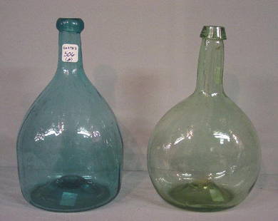 TWO BLOWN BOTTLES. Aqua Zanesville club: TWO BLOWN BOTTLES. Aqua Zanesville club with twenty-four faint, swirled ribs. Wear and blisters. 8 3/4"h. And a a pale green glob. Wear and a few blisters. 8 1/8"h.