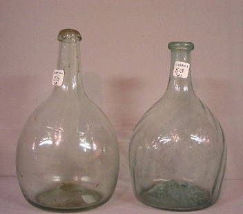 TWO PALE AQUA BOTTLES. Mantua club with: TWO PALE AQUA BOTTLES. Mantua club with sixteen swirled ribs. Applied lip. Wear and some residue. 8"h. And a very pale, plain bottle with applied lip. Some residue. 8 1/2"h.