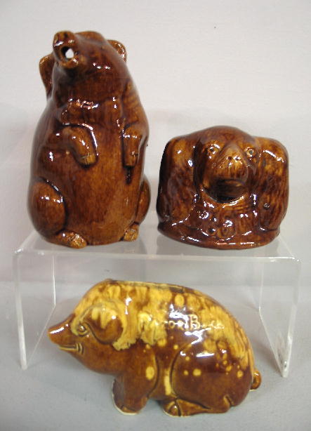 THREE ANIMAL POTTERY PIECES: Pictured is a "Razor: THREE ANIMAL POTTERY PIECES: Pictured is a "Razor Back" hog bank with brown and yellow mottled glaze. 3 1/2"h. The other two pieces are yellow clay with brown glaze. Pig creamer with applied handle, 6