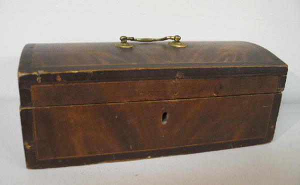 GRAIN DECORATED DOME TOP BOX. Dovetailed pine with: GRAIN DECORATED DOME TOP BOX. Dovetailed pine with original paint imitating flame grain mahogany. Brass bale handle and wire staple hinges. Minor wear and edge damage. 11 3/4"w. 5 3/4"d. 4 1/2"h.