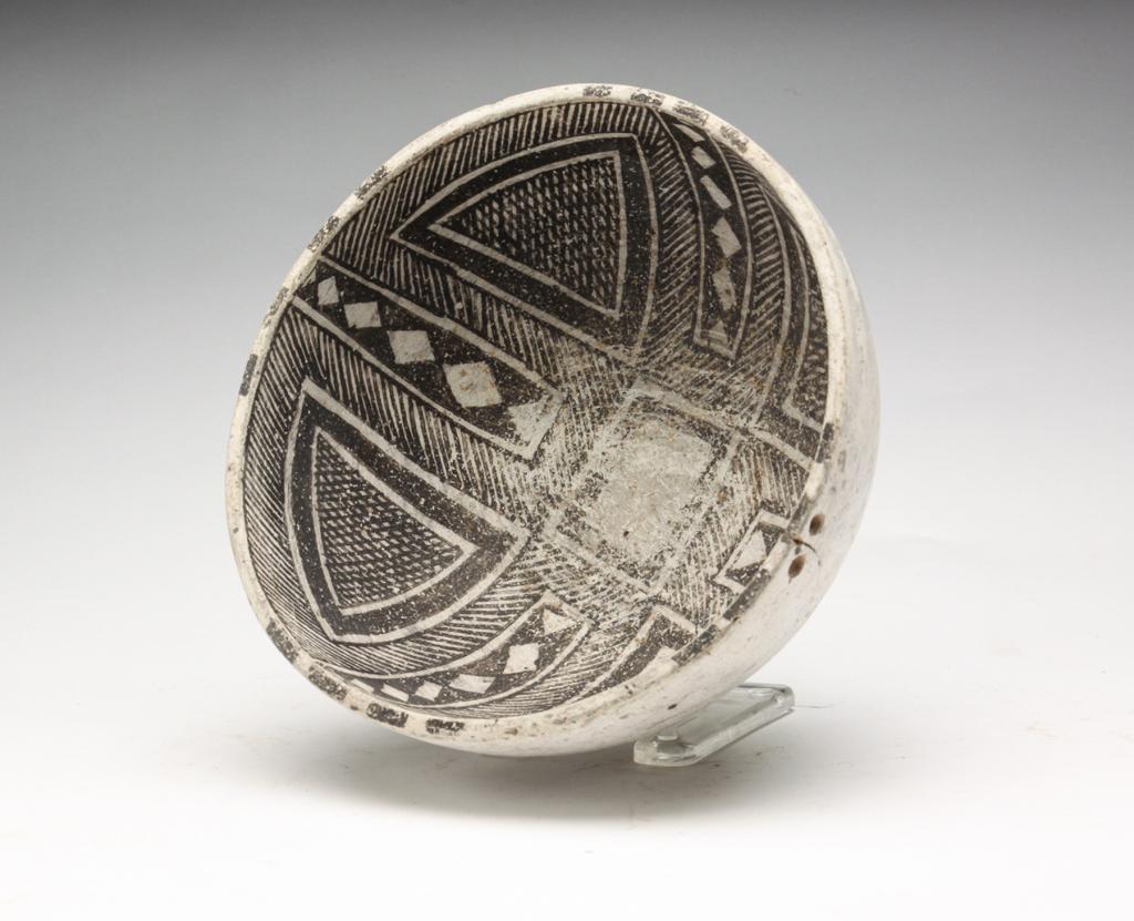 NATIVE AMERICAN POTTERY BOWL.: Geometric designs to inside and light exterior. Two holes near the rim. Crack and wear. 3.75"h. 8" diameter.