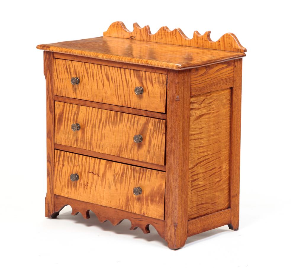 AMERICAN DIMINUTIVE CHEST OF DRAWERS.: Mid 19th century, curly maple and oak with poplar secondary. Square nail construction. Three nailed drawers with replaced pulls, scalloped edge backsplash and apron and chamfered corners with lamb's t
