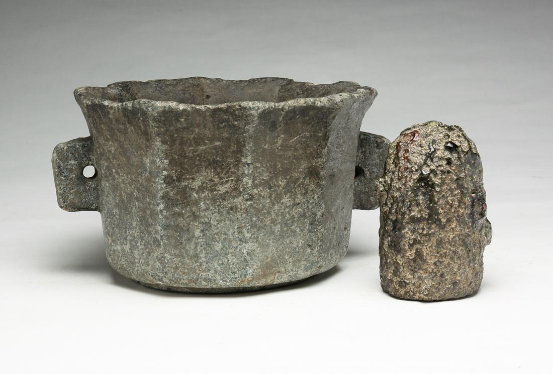 ASIAN STONE JARDINIERE AND POTTERY PIECE.: Probably late 19th-early 20th century. Paneled with flared rim and lug handles. Weathered with edge loss. 5.5"h. 9"d. Together with a cylindrical pottery piece with heavily alligatored glaze. 4.75"h.