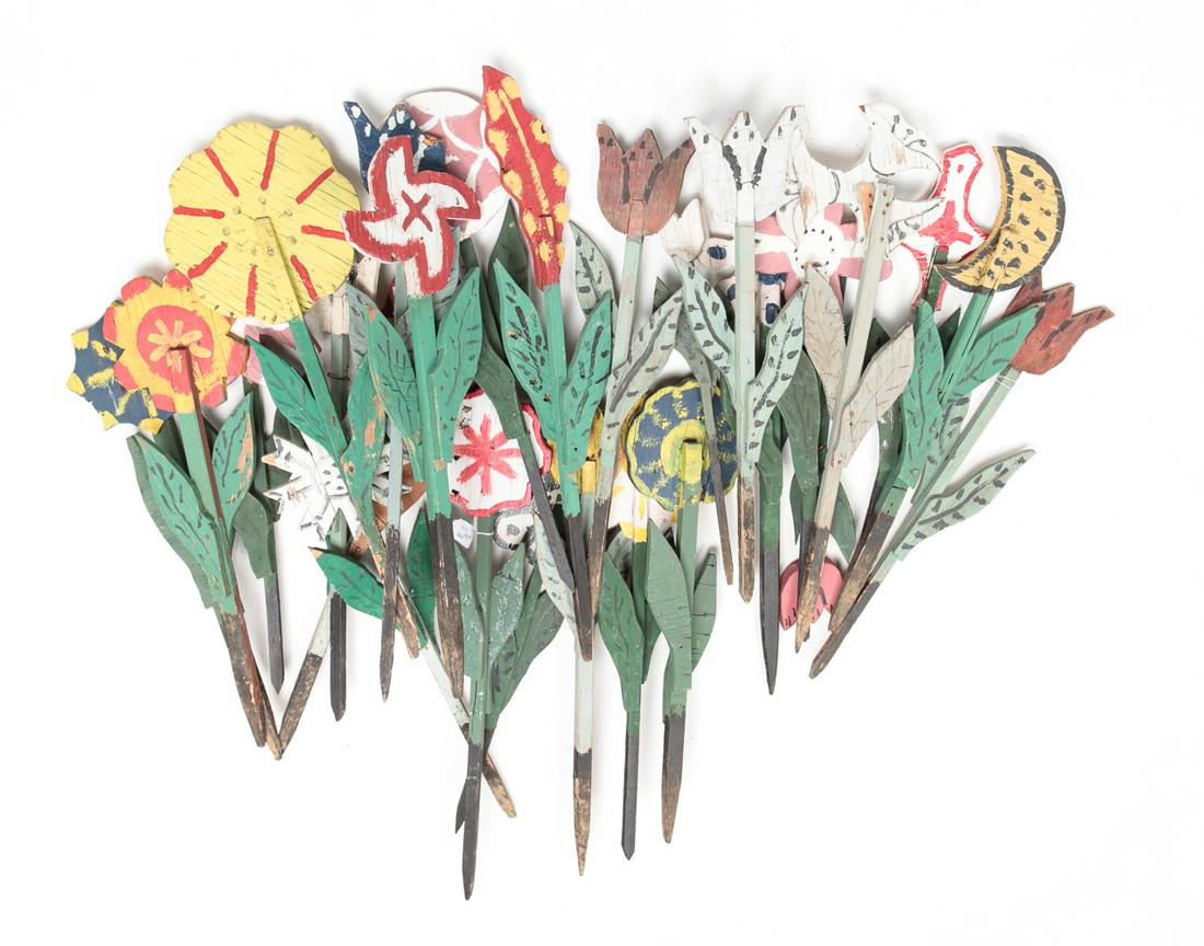 GROUP OF FOLK ART WOOD YARD FLOWERS.: American, mid 20th century. Twenty-five painted wood flowers in different styles and colors. Varying wear and loss. 16"h to 23"h.
