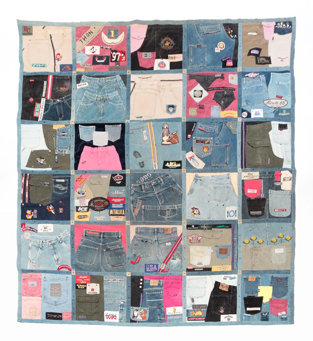 AMERICAN JEAN DENIM QUILT.: Last quarter-20th century. Various jean pieces quilted together. Attached patches. Wear and staining. 90" x 98".