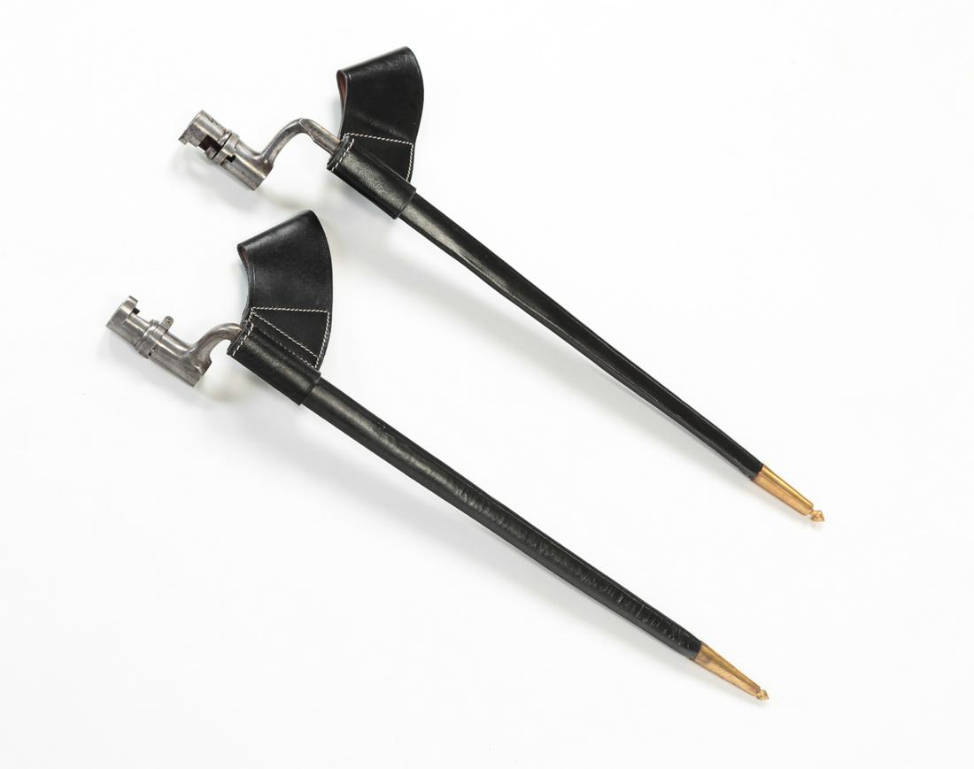 TWO SOCKET BAYONETS WITH REPRODUCTION SCABBARDS: Two socket bayonets with reproduction leather scabbards. 20-3/4" long. One marked, "US" and "28", the other unmarked.