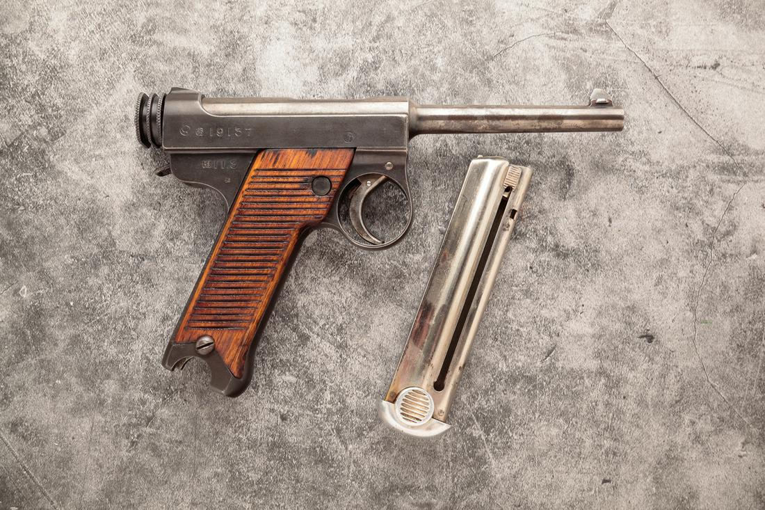 JAPANESE NAMBU 11.3 TYPE 14 8MM SEMI AUTO PISTOL: Japanese Nambu 11.3 Type 14 8mm semi automatic pistol. Wooden grips with blued frame and barrel. 4-1/2" barrel, 8-1/2" overall. Matching serial numbers including magazine: 19137. Requires ATF form 447