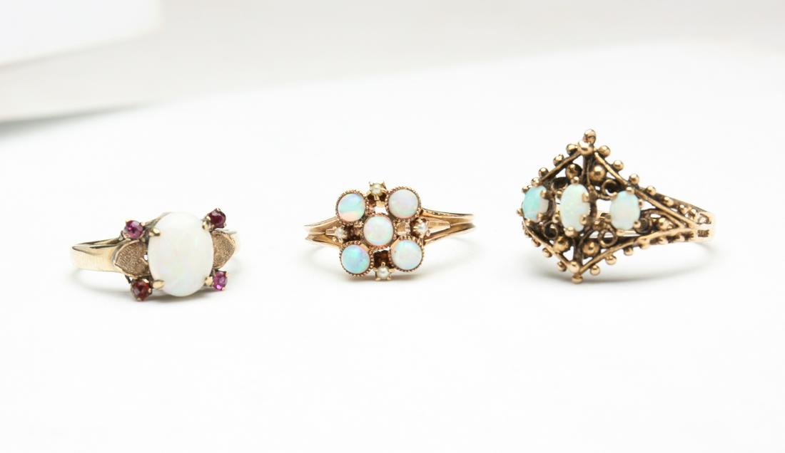 THREE VINTAGE YELLOW GOLD OPAL RINGS. (1 of 8)