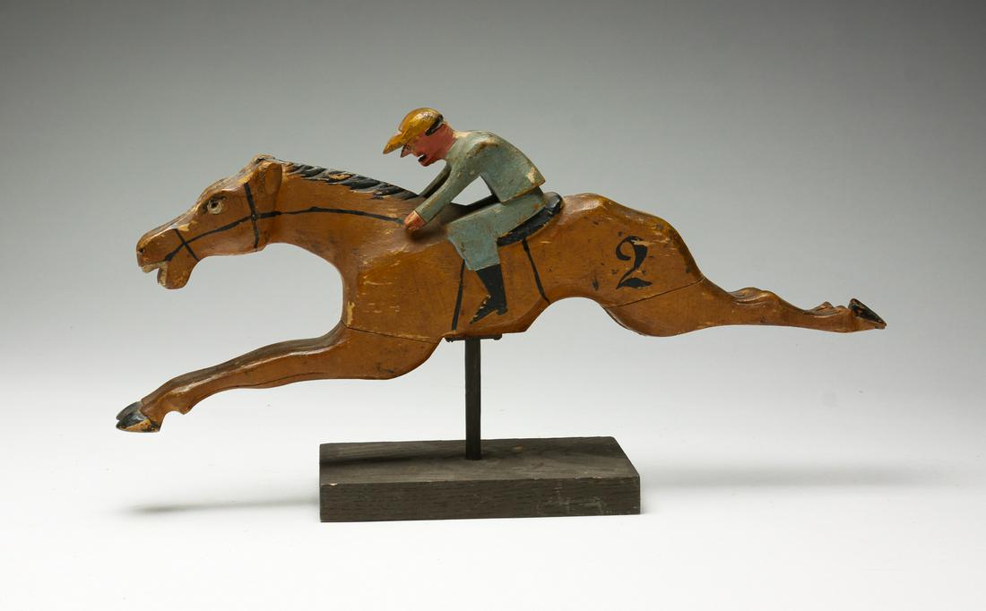 H.C. EVANS RACING GAME HORSE.: American, 2nd quarter 20th century. Wooden horse and jockey with original paint from H.C. Evans (Chicago) Portable Candy Race Track game. Wear, missing tail. 8"h. 16"l. including base.