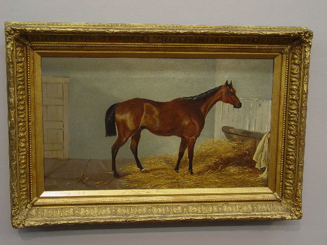 OIL ON CANVAS. Bay race horse in a straw