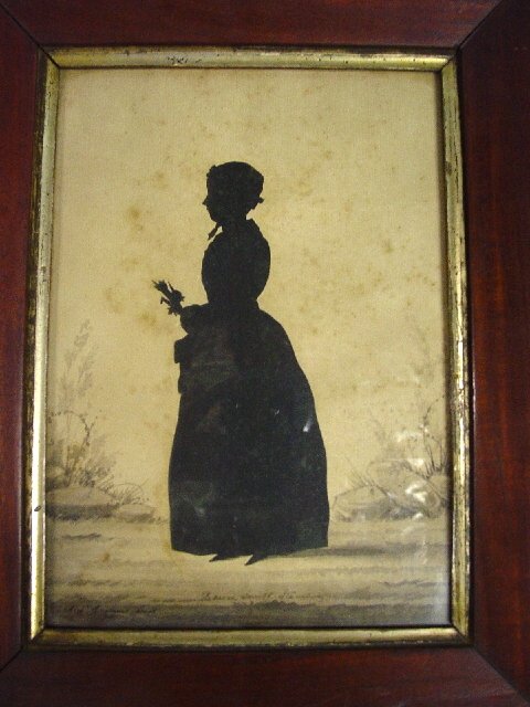 EDOUART SILHOUETTE. Full length cutout p: EDOUART SILHOUETTE. Full length cutout portrait of "Rebecca Smith Stamsbury" (?) carrying a bouquet of flowers. Handpainted background in ink wash on laid paper. Signed "Aug. Edouart - fecit 1841". Li