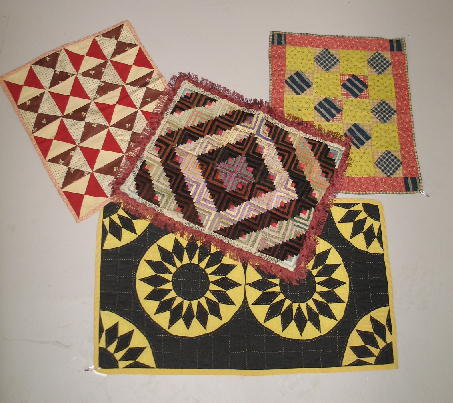 FOUR DOLL QUILTS. Pictured is a nicely done yello: FOUR DOLL QUILTS. Pictured is a nicely done yellow and black cotton pieced Sunflower hand quilted in yellow. 13"w 21 1/2"l. Second is a Hour Glass variation in red, brown and white reversing to red an