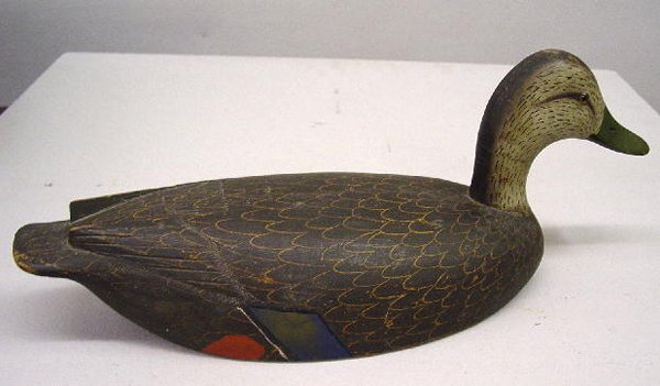 BLACK DUCK DECOY. Paper label on the base reads "Mr: BLACK DUCK DECOY. Paper label on the base reads "Mr. Nickols, Smith Falls, Ontario, Canada about 1920". Well carved with relief tail feathers and glass eyes. Original paint has very good color. A stra