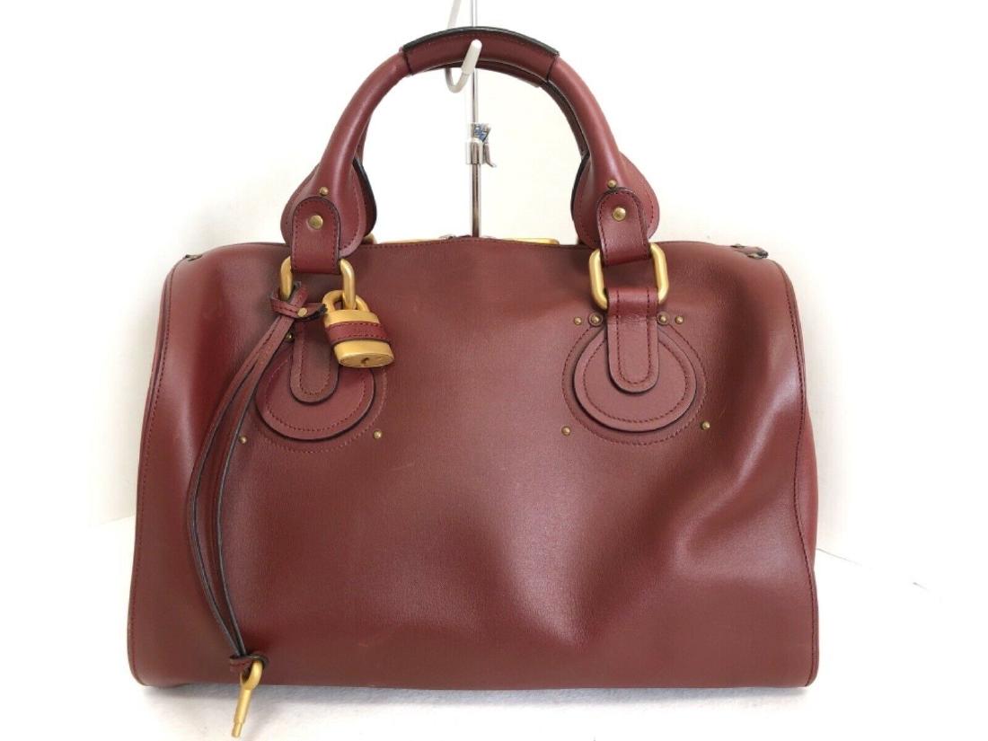 CHLOE HANDBAG: Brand: Chloe Style: Handbag Color: Bordeaux Material: Leather Product Name: Aurore Accessories: Padlock (with key) All Bidhaus items come with an Authenticity Guarantee. Unless specified above, item d