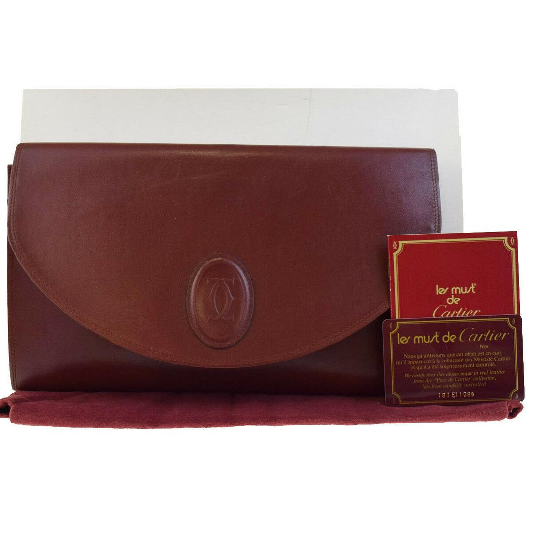 Authentic Cartier Leather Clutch Bag: Brand: Cartier Style: Clutch Bag Material: Leather Color: Bordeaux Size: Medium Size (Inches): W 10.4 x H 6.3 x D 0.6 "(approx.) Strap Drop: Country of Origin: Italy Comes With: All Bidhaus items come