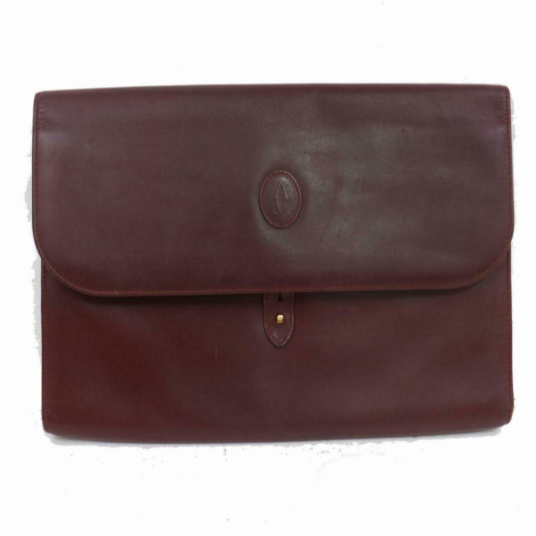 Authentic Cartier Leather Clutch: Brand: Cartier Style: Clutch Material: Leather Color: Bordeaux Size: Height: 9.25 inch(approx) /23.5 cm(approx) Depth: 1.18 inch(approx) /3 cm(approx) Width: 12.5 inch(approx) /32 cm(approx) Comes Wit