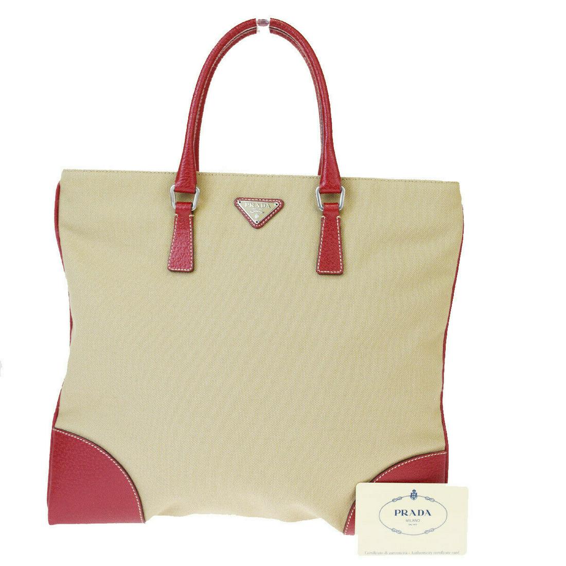 Authentic PRADA Canvas, Leather Handbag: Brand: PRADA Material: Canvas, Leather Style: Handbag Color: Beige, Red Size (HxWxD): 27cm x 30cm x 1cm / 10.62'' x 11.81'' x 0.39'' Country of Origin: Italy All Bidhaus items come with a 100% money-b