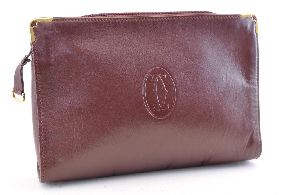 Authentic Cartier Leather Clutch Bag: Brand: Cartier Material: Leather Style: Clutch Bag Color: Bordeaux Size(inch): W10.2 x H7.4 x D1.9â€³(Approx) Country of Origin: â€“ Accessory: There is no padlock and dust bag. We will send 
