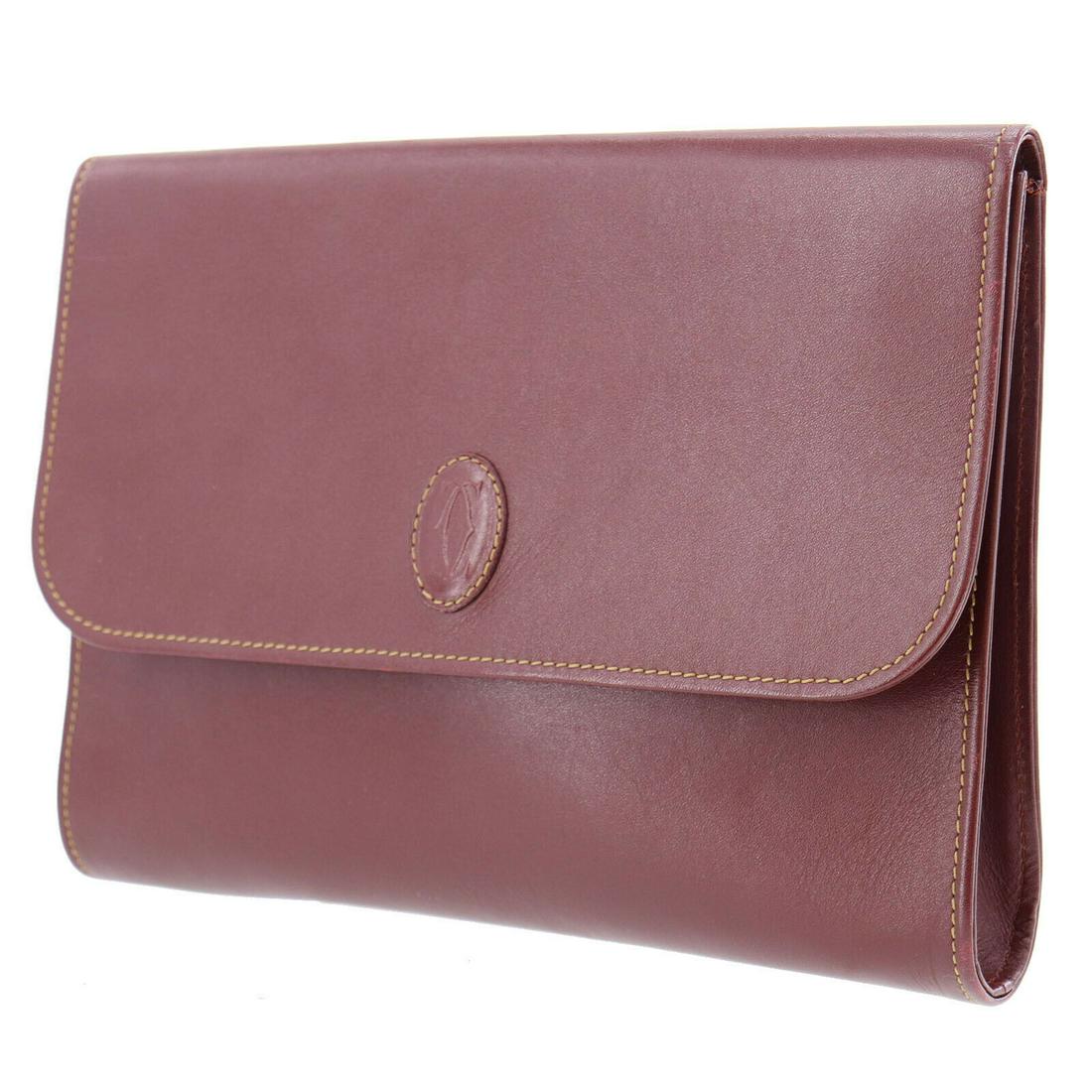 Authentic CARTIER Leather Clutch: Brand: CARTIER Material: Leather Style: Clutch Color: Bordeaux Size(Inch): H 7.4 x D 1.1 x L 10.2 Country of Origin: Italy Come with: - All Bidhaus items come with a 100% money-back authenticity guara
