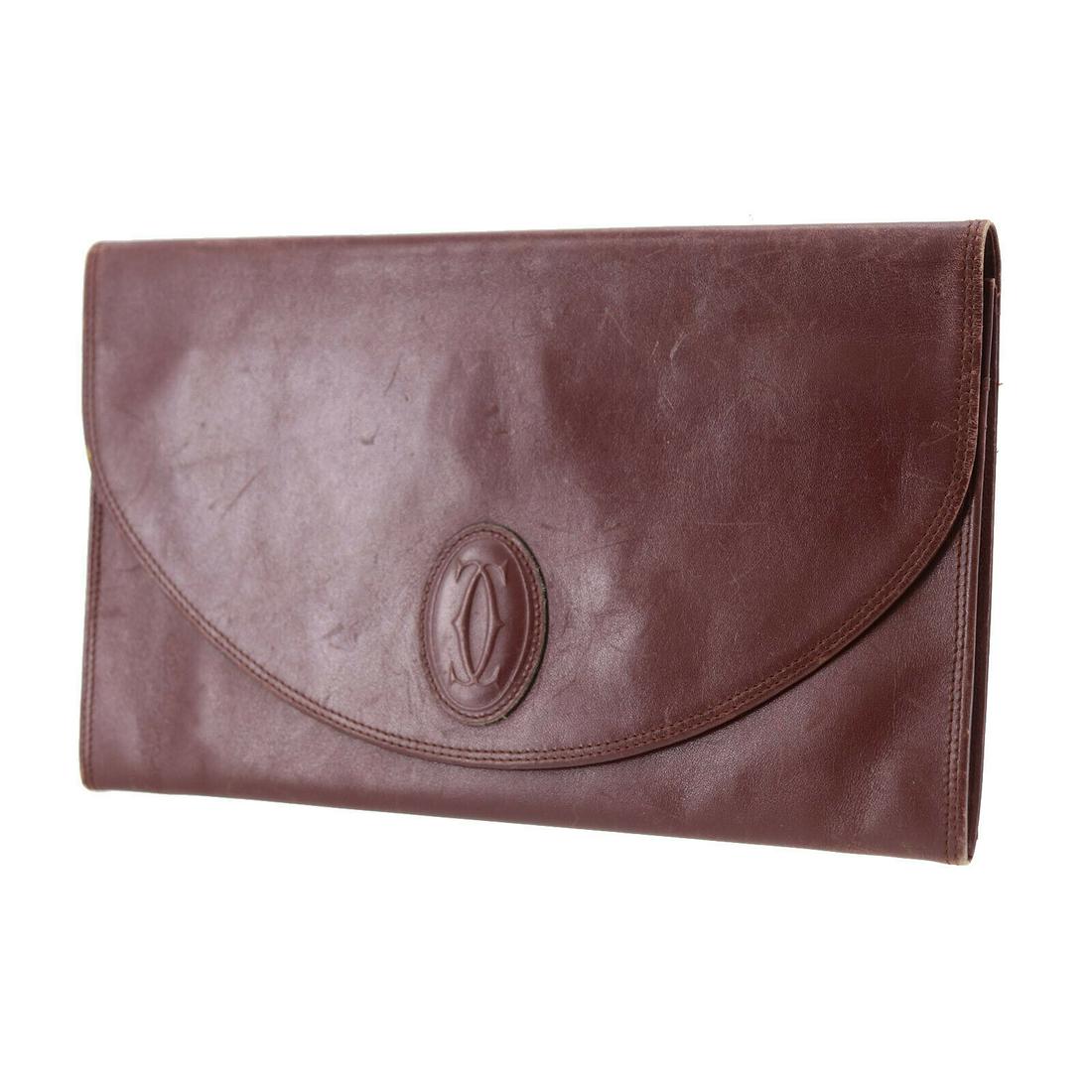 Authentic CARTIER Leather Clutch: Brand: CARTIER Material: Leather Style: Clutch Color: Bordeaux Size(Inch): H 6.6 x D 0.5 x L 11.0 Country of Origin: Italy All Bidhaus items come with a 100% money-back authenticity guarantee. Please 