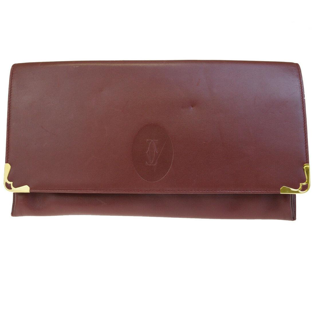 Authentic CARTIER Leather Clutch hand bag: Brand: CARTIER Material: Leather Style: Clutch hand bag Color: Bordeaux Size(inch): W 10.6 x H 5.9 x D 0.8 "(approx.) Country of Origin: - Come with: - All Bidhaus items come with a 100% money-back au