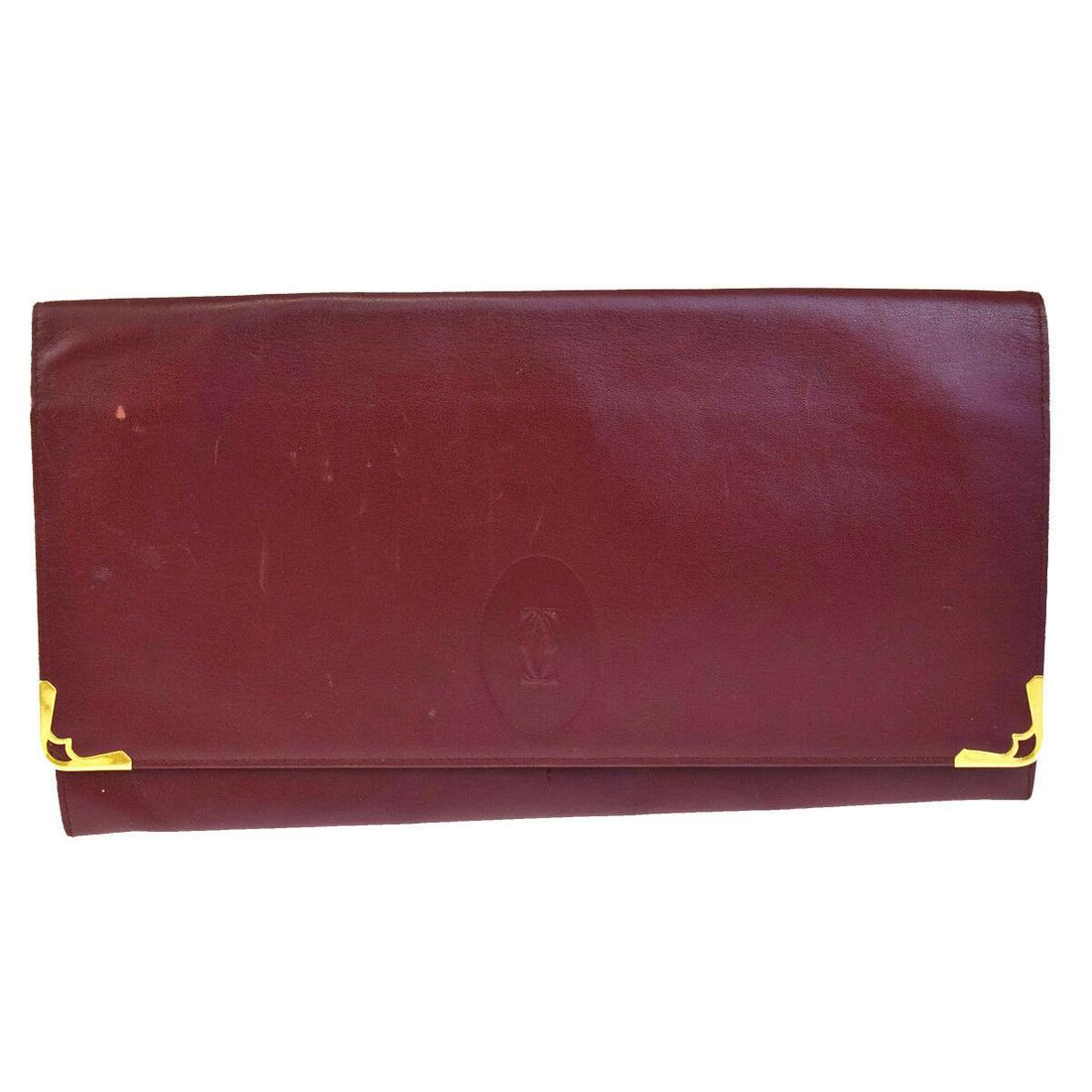 Authentic CARTIER Leather Clutch Hand Bag: Brand: CARTIER Material: Leather Style: Clutch Hand Bag Color: Bordeaux, Size(inch): W 11 x H 5.9 x D 0.4 "(approx.) Country of Origin: Italy Come with: - All Bidhaus items come with a 100% money-back