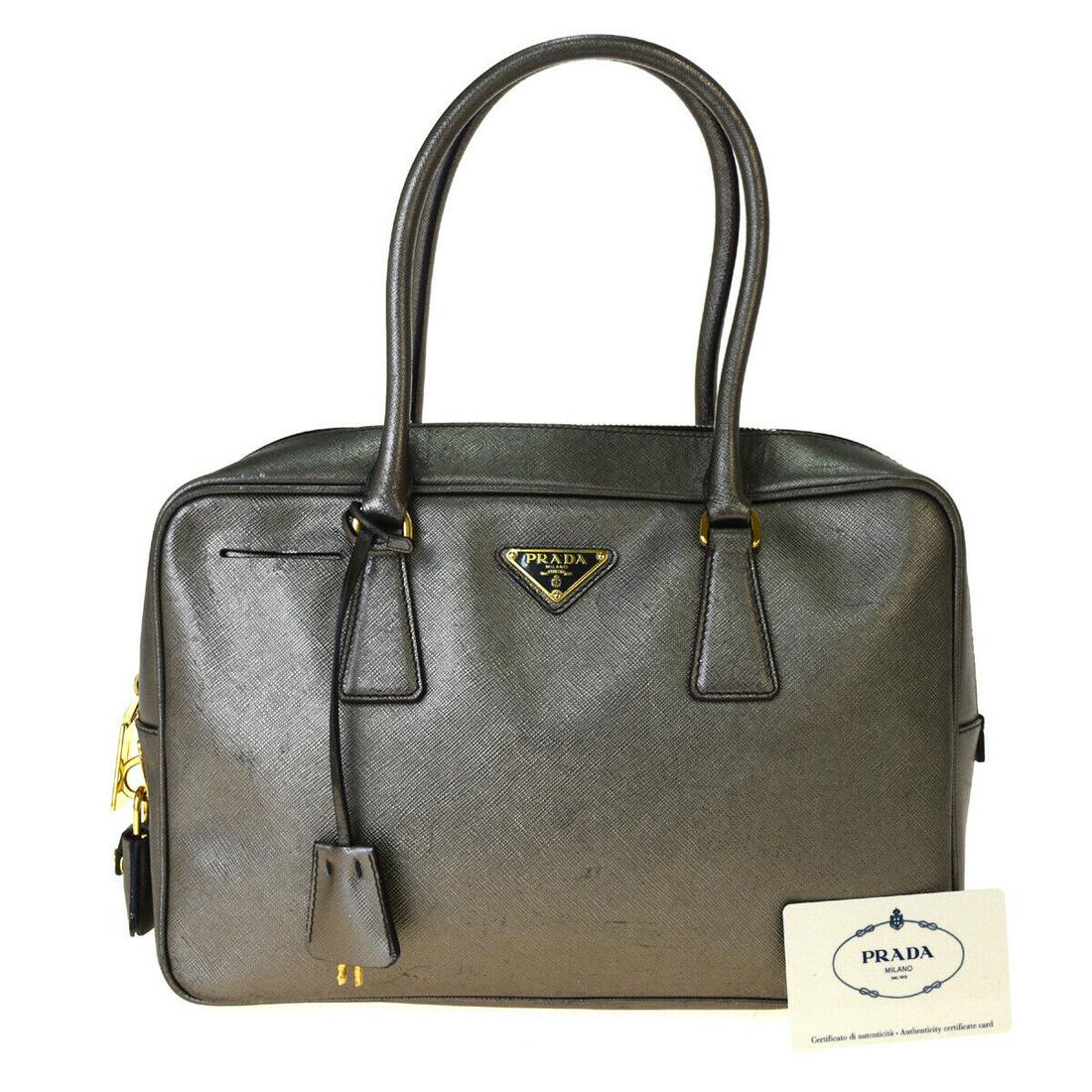 Authentic PRADA Leather Hand bag: Brand: PRADA Material: Leather Style: Hand bag Color: Silver Size(inch): W 11.8 x H 7.9 x D 3.1 "(approx.) Country of Origin: Italy Come with: Authenticity Card,Key bell,Padlock,Key All Bidhaus items 