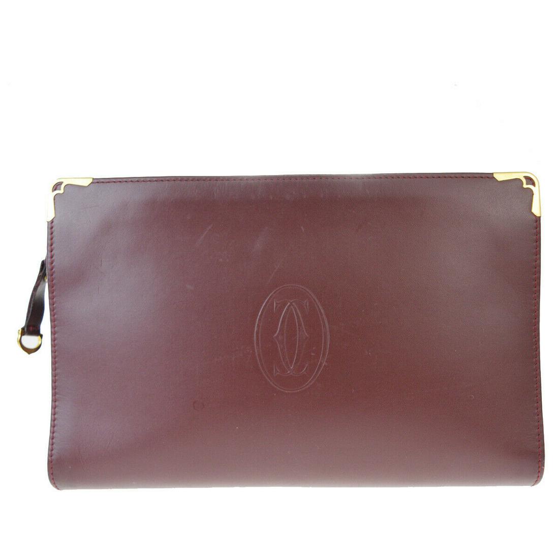 Authentic CARTIER Leather Clutch Bag: Brand: CARTIER Material: Leather Style: Clutch Bag Color: Bordeaux Size(inch): W 10.2 x H 6.7 x D 2.4 "(approx.) Country of Origin: Italy Come with: - All Bidhaus items come with a 100% money-back aut