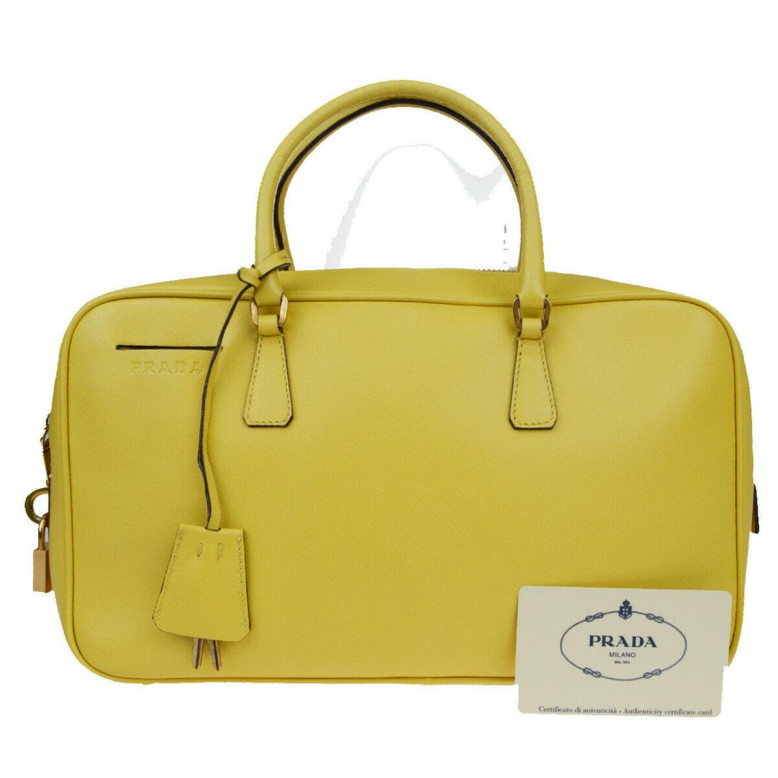 Authentic PRADA Leather Hand Bag: Brand: PRADA Material: Leather Style: Hand Bag Color: Yellow Size(inch): W 11.4 x H 6.7 x D 2.4 "(approx.) Country of Origin: Italy Come with: Key*2,Padlock,Authenticity Card,Keybell All Bidhaus items