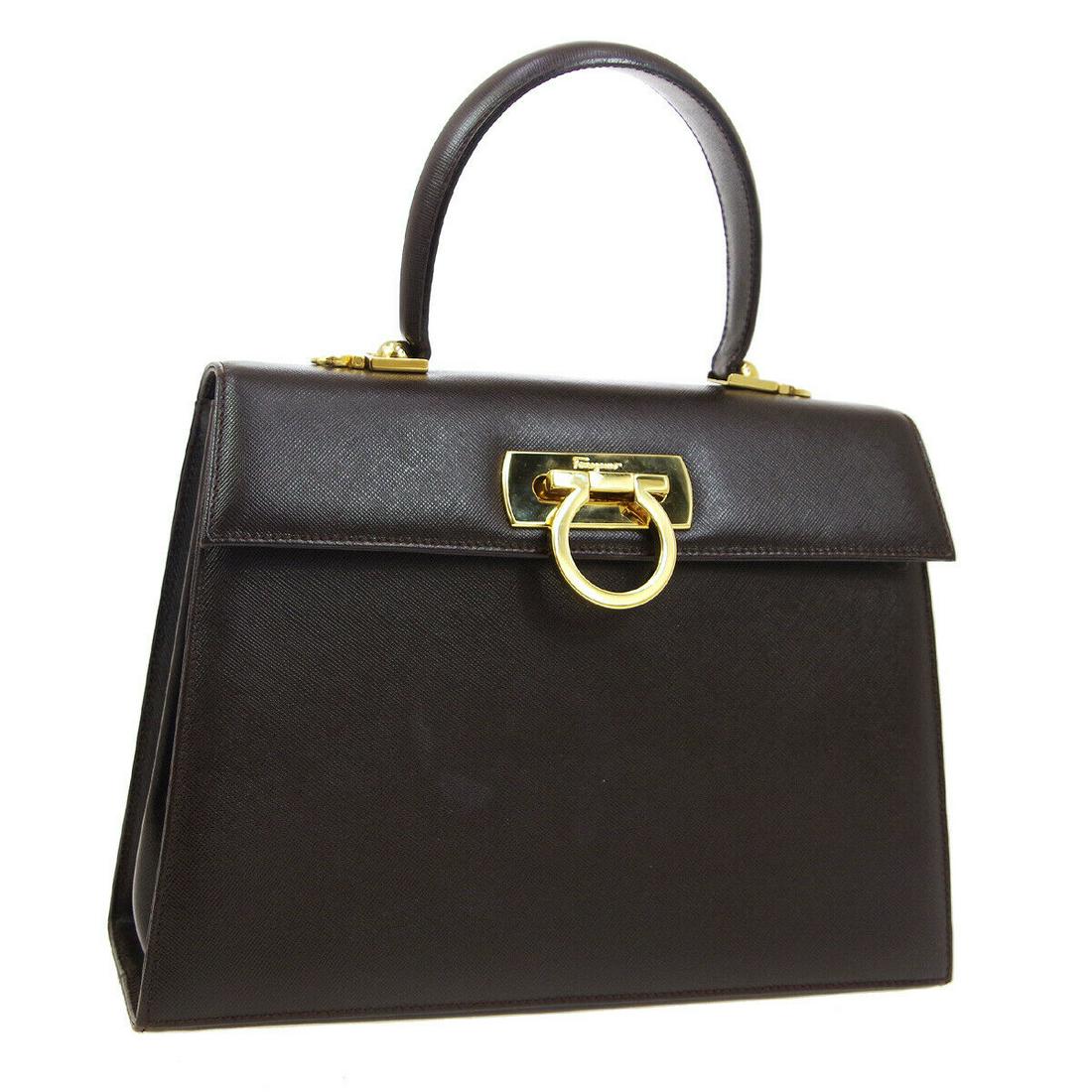 Authentic SALVATORE FERRAGAMO Leather Hand bag: Brand: SALVATORE FERRAGAMO Material: Leather Style: Hand bag Color: Dark Brown Size(inch): W10.2 x H8.3 x D3.9 " / Strap Drop: 4.3 or 19.7 - 21.3 Country of Manufacture: Italy Come with: Shoulder Stra