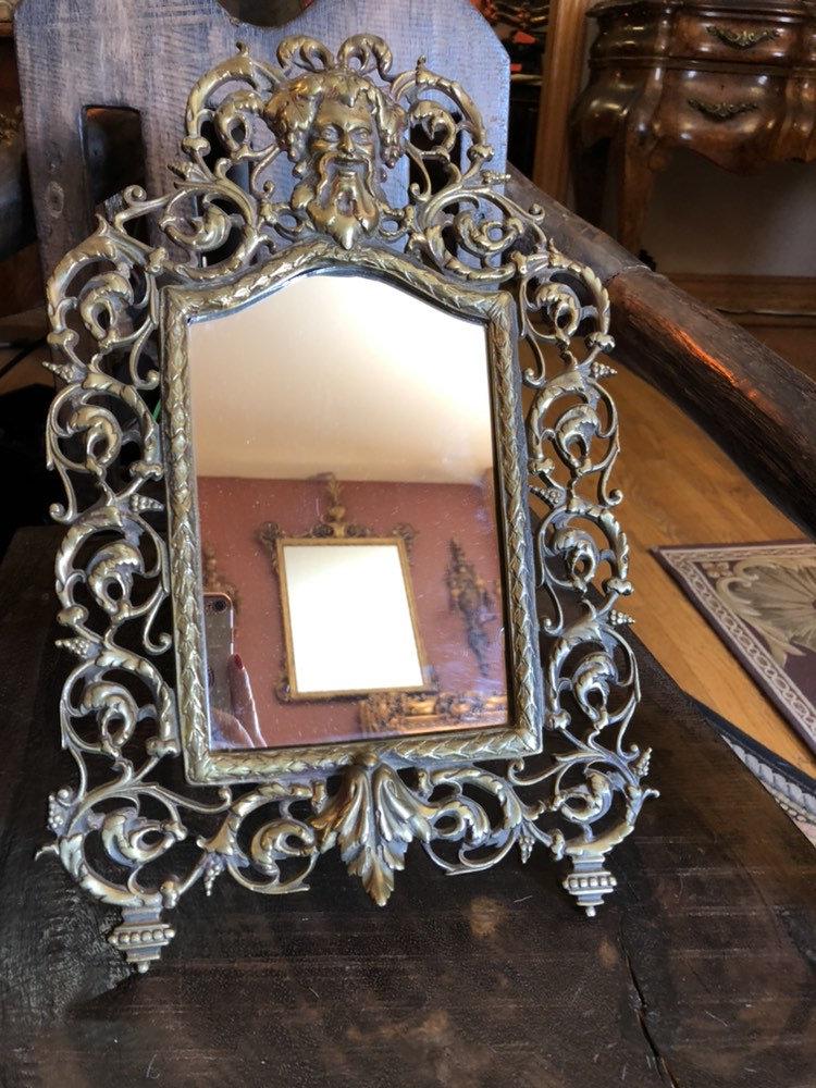 Antique Victorian Ornate Easel Back Devil Head Beveled: Antique Victorian Style Late 18th C Ornate Brass Easel Back Devil Head Beveled Glass Framed Table Mirror The mirrors also have a brass hoop so they can be hung on a wall instead of standing on the eas