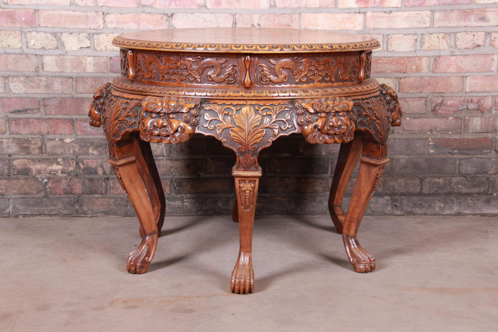 Authentic Ornate Asian Carved Walnut Center Table With: An exceptional ornate Asian center table or tea table 20th Century Walnut with ornate carved faces dragons foliage and paw feet. Top with mother-of-pear inlay. Measures: 35"W x 35"D x 25"H. Very good 