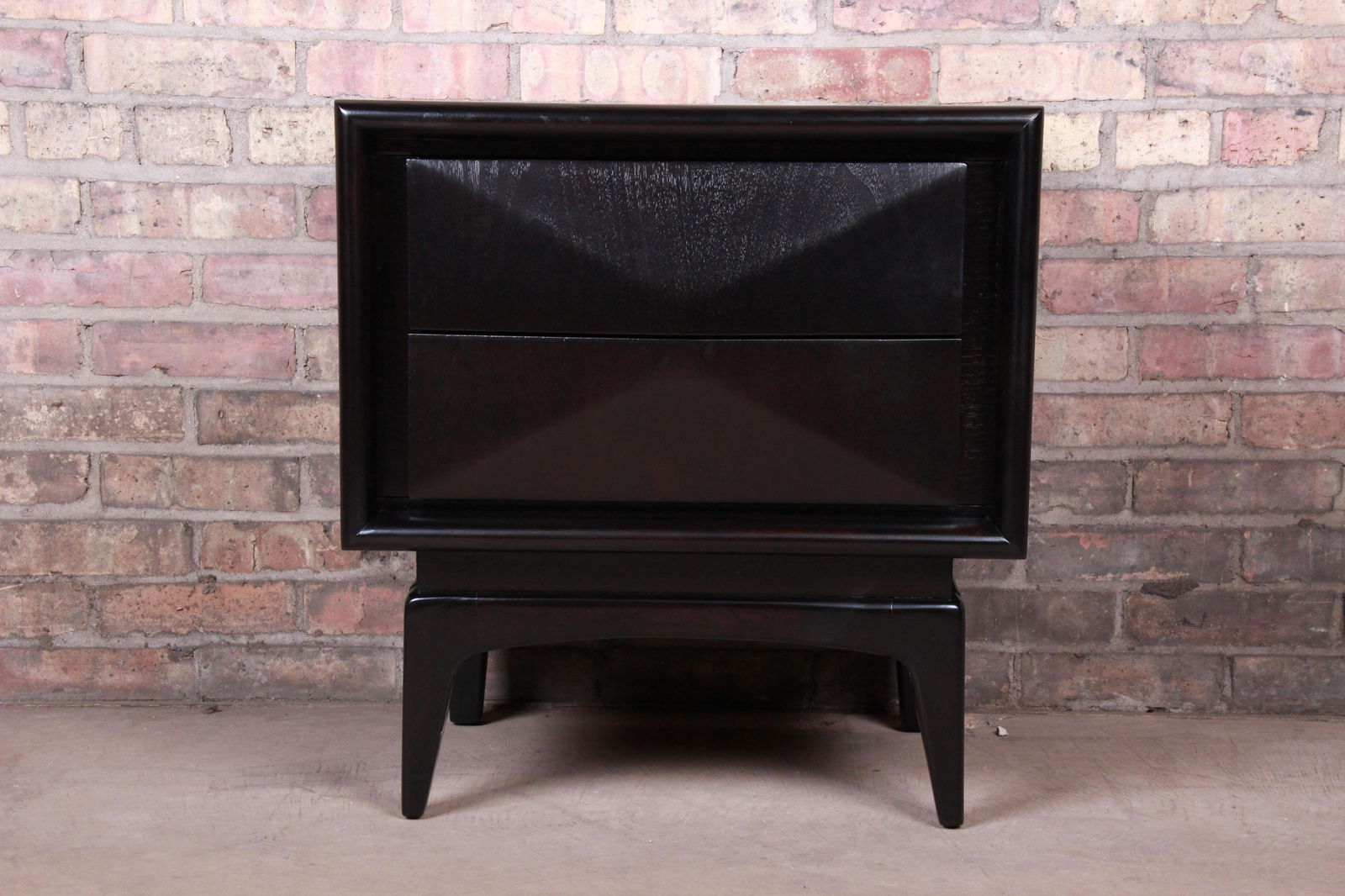 Authentic Mid-Century Modern Ebonized Sculpted Walnut: A stunning mid-century modern diamond front nightstand In the manner of Vladimir Kagan By United Furniture Co. USA 1960s Ebonized walnut with unique sculpted diamond front design. Measures: 23"W x 16"