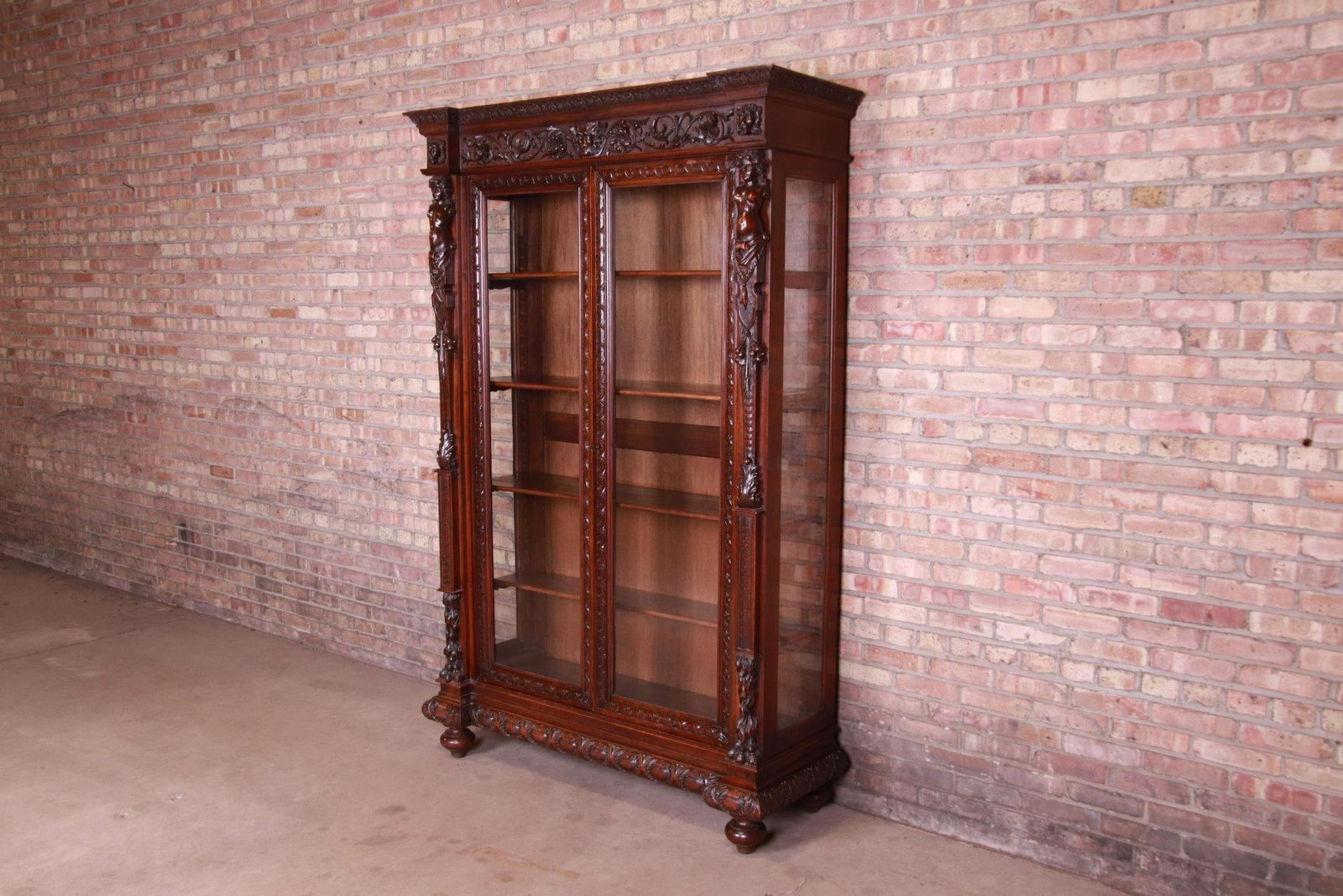 Authentic 19th Century French Renaissance Ornate Carved: An exceptional monumental antique French Renaissance bookcase France Circa 1850 Ornate carved walnut with female busts lion heads faces and foliage. Original glass fronts and sides and original key is